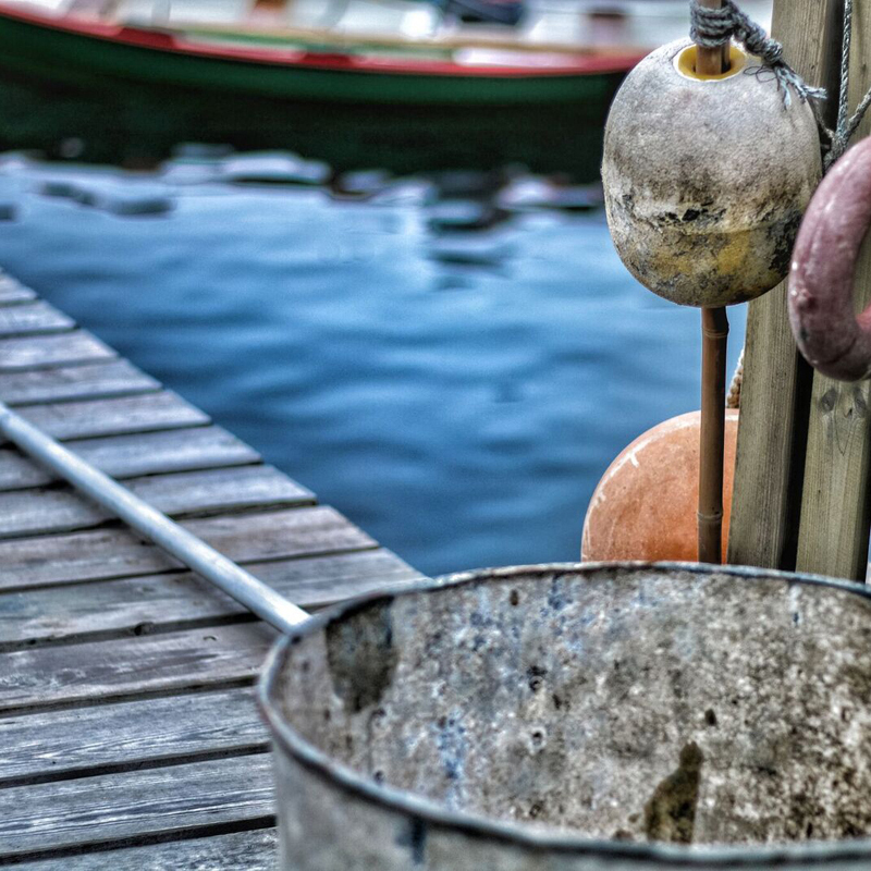 Gamlar netakúlur og málmfata á trébryggjunni