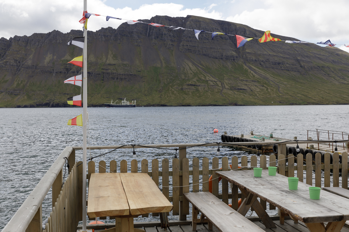 Útiborð og fánaborðar með útsýni yfir fjörðinn og fjöllin